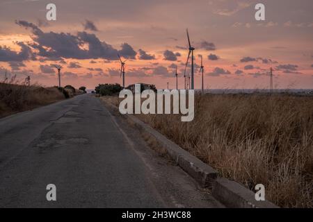 Straße mitten in einem Windpark. Isola di Capo Rizzuto, Crotone, Kalabrien, Italien Stockfoto