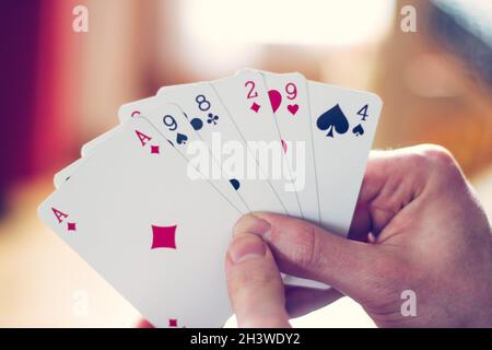 Spielkarten: Poker-Karten in der Hand eines jungen Mannes Stockfoto
