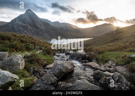 Episch dramatische Landschaftsaufnahme von Llyn Ogwen und Tryfan im Snowdonia National Park mit Bach und Felsen im Vordergrund Stockfoto