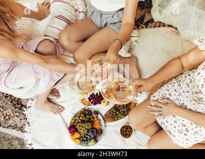 Crop Frauen trinken Wein während des Picknicks Stockfoto