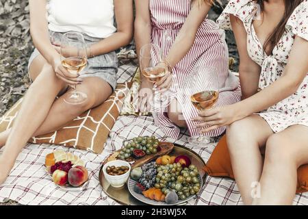 Crop Frauen trinken Wein während des Picknicks Stockfoto