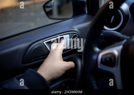 Nahaufnahme des Schlosses zum Öffnen der Seitentür des Wagens, zu dem die Hand eines Mannes greift Stockfoto