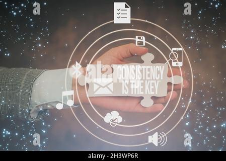 Das Zeichen, das Konsistenz anzeigt, ist der Schlüssel. Wort für durch Brechen schlechte Gewohnheiten und Formung gute Hand Halten Puzzle Stück Entsperren Neu Stockfoto