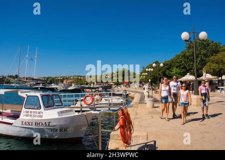 Krk, Kroatien - 2. September 2021. Touristen und Einheimische spazieren entlang der Küste in der historischen mittelalterlichen Küstenstadt Krk auf der Insel Krk Stockfoto