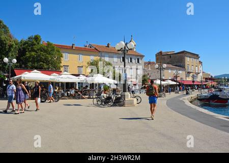 Krk, Kroatien - 2. September 2021. Touristen und Einheimische spazieren entlang der Küste in der historischen mittelalterlichen Küstenstadt Krk auf der Insel Krk Stockfoto