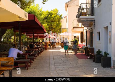 Krk, Kroatien - 2. September 2021. Touristen und Einheimische spazieren durch die historischen Straßen der mittelalterlichen Altstadt von Krk auf der Insel Krk Stockfoto