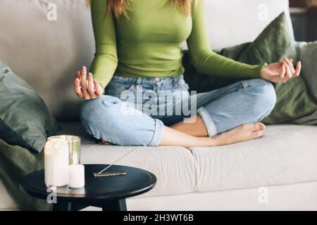 Crop weiblich meditieren auf dem Bett Stockfoto