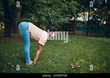 Indische Frau, die im Sommerpark im Freien Yoga macht Stockfoto