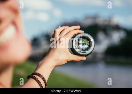 Fotografie in Salzburg: Handgehaltenes Kameraobjektiv mit der Altstadt von Salzburg Stockfoto