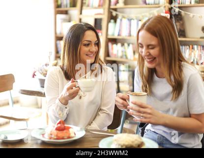 Fröhliche, multiethnische Frauen genießen das Mittagessen im Café Stockfoto