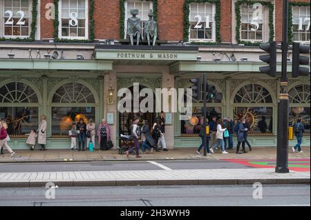 Leute, die in Piccadilly einkaufen gehen, kommen an Fortnum & Mason vorbei, einem nobleren Kaufhaus. London, England, Großbritannien. Stockfoto