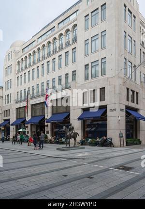 Menschen, die sich auf dem Straßenbelag vor dem Ralph Lauren-Laden, der New Bond Street, Mayfair, London, England, VEREINIGTES KÖNIGREICH Stockfoto