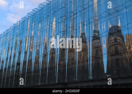 Erstaunliche Reflexion eines traditionellen klassischen Gebäudes in einem modernen Glas.Fassade auf der Straße von Paris Frankreich Stockfoto