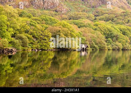 Reflexionen, die an einem frühen Herbsttag in Llyn Dinas, Gwynedd Snowdonia Wales, Großbritannien, festgehalten wurden Stockfoto