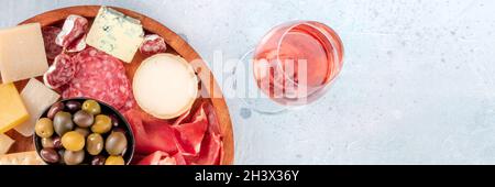 Aufschnitt und Käse-Panorama-Banner, von oben mit Rosenwein aufgenommen Stockfoto