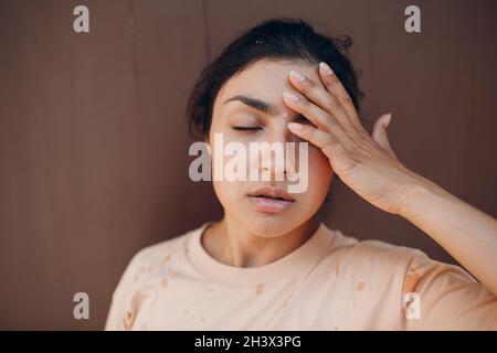 Gestresste Frau, die an einem Hitzschlag leidet, der draußen mit kaltem Wasser erfrischt. Wetter abnorme Wärme Konzept. Stockfoto