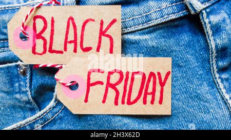 Stylische Jeans mit schwarzer freitagsflagge. Black friday und Cyber monday Sale Discount Concept Tag mit blauer Jeans. Schwarzer freitag wr Stockfoto