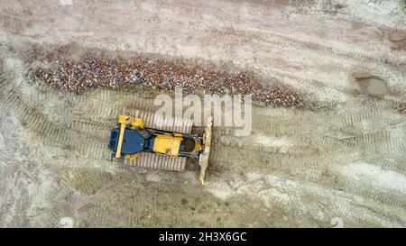 Bagger oder Planierraupen bei Arbeiten auf Industriebaustellen. Luftaufnahme mit Drohne Stockfoto