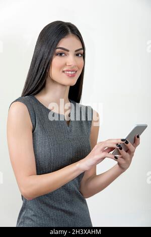 Junge Geschäftsfrau mit Smartphone und Lächeln. Stockfoto