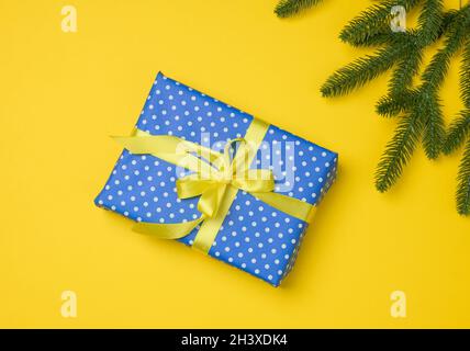 Blaue Geschenkbox mit Band auf einem grauen Hintergrund gebunden, Draufsicht. Stockfoto