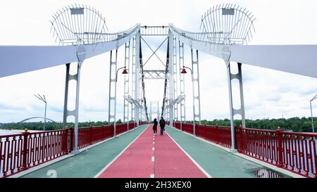 Park Fußgängerbrücke über den Fluss Dnjepr, die den zentralen Teil von Kiew mit dem Park und den Stränden von Tru verbindet Stockfoto