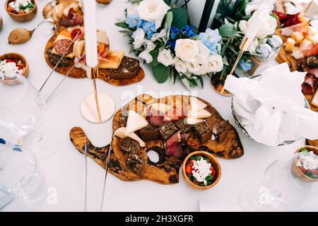 Schneidebretter mit Käse, Prosciutto und schwarzem Brot auf dem Festtisch. Stockfoto