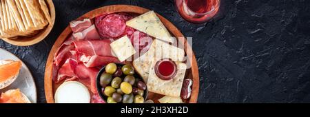 Wurstwaren- und Käseplatten-Panorama mit Rotwein und Oliven Stockfoto