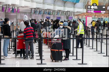 Mississauga, Kanada. Oktober 2021. Reisende mit Gesichtsmasken stehen am 30. Oktober 2021 am internationalen Flughafen Toronto Pearson in Mississauga, Ontario, Kanada, an. Ab Samstag müssen Reisende, die mindestens 12 Jahre alt sind, nachweisen, dass sie während ihrer Reisen innerhalb Kanadas oder im Ausland vollständig gegen COVID-19 geimpft wurden. Quelle: Zou Zheng/Xinhua/Alamy Live News Stockfoto