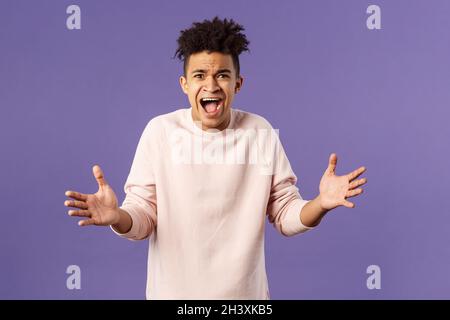 Porträt eines besorgten, verärgerten und frustrierten jungen Mannes, der kaum glauben kann, dass er verloren hat, fragt, warum, spreizte die Hände in Bestürzung zur Seite, beschwert sich Stockfoto