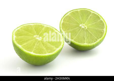 Kalk im Abschnitt isoliert auf weißem Hintergrund. Reife grüne Zitrusfrüchte für Cocktails und alkoholische Getränke. Stockfoto