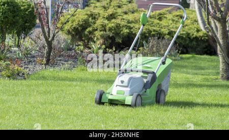 Rasenmäher auf einem grünen Rasen. Schneiden des Grases auf dem Rasen im Garten. Stockfoto