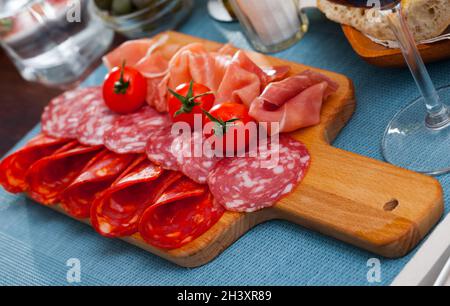 Spanische leckere Mahlzeit Würste und Jamon mit Tomaten schneiden, Nahaufnahme Stockfoto