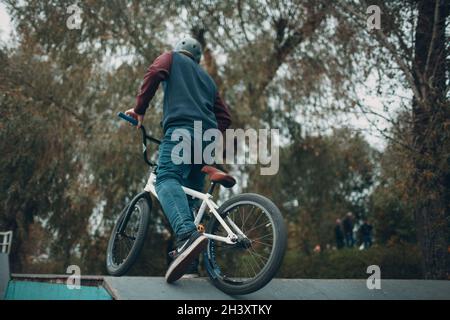 Professioneller junger Sportler Radfahrer mit bmx Fahrrad im Skatepark. Stockfoto