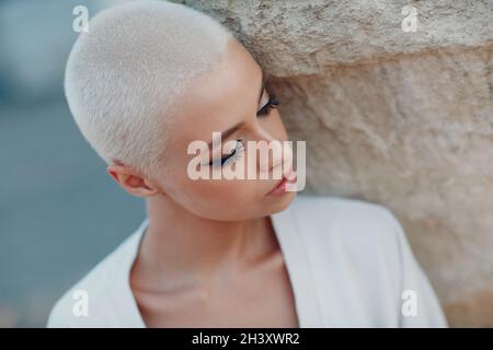 Millenial junge Frau blond kurze Haare im Freien Porträt. Stockfoto