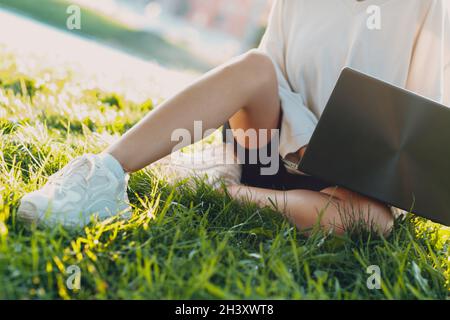 Millenial junge Frau blonde kurze Haare im Freien lächelnd Porträt mit Laptop. Stockfoto