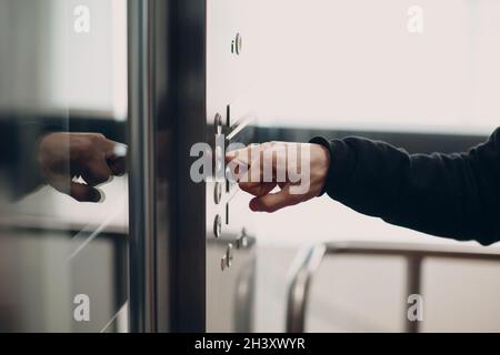 Nahaufnahme des Zeigefingerknochens, das während des Coronavirus-Pandemiekonzepts der covid-19-Quarantäne den Tastenaufzug drückt Stockfoto