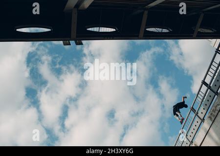 Junger sportlicher Kerl, der Parkour an der Stadtstraße macht. Stockfoto