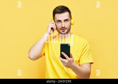 Hübscher kaukasischer Mann, der Musik von seinem Telefon und seinen Kopfhörern hört Stockfoto