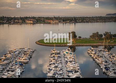 San Diego, Kalifornien, USA - 4. Oktober 2021: South Embarcadero Boardwalk. Sonnenaufgang über der Nordinsel Coronado mit Ozeantor hinten und Yachthafen Stockfoto