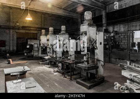 Alte vertikale Fräsmaschinen mit angeflanschten Elektromotoren für die Metallbearbeitung in der Werkstatt des Industriewerks. Stockfoto