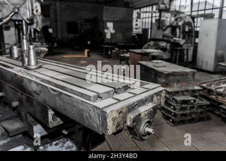 Teil einer alten horizontalen Fräsmaschine mit Geräten und Werkzeugen für die Metallbearbeitung in der Werkstatt eines Industriewerks. Stockfoto