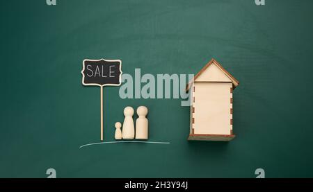 Hölzerne Familienfiguren, Modellhaus. Immobilienkauf. Umzug in neue Wohnungen Stockfoto