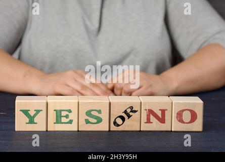 Holzwürfel mit der Aufschrift ja und nein auf einem nlue Hintergrund. Das Konzept der Analyse und Auswahl der richtigen Entscheidung Stockfoto