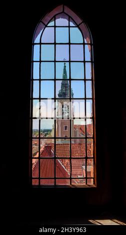 Blick auf die Heilig-Geist-Kirche und historische Gebäude durch das Buntglasfenster des Alten Rathauses in Torun, Polen. August 2 Stockfoto