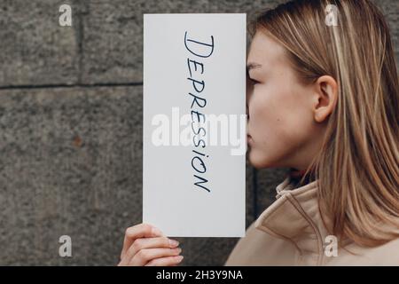 Frau schließen Gesicht mit Blatt Papier mit Wort Depression. Stockfoto