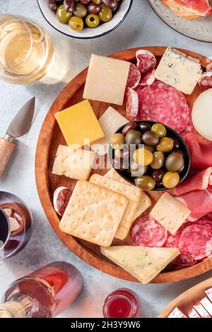 Aufschnitt und Käseplatte aus der Nähe mit Wein und Oliven, von oben geschossen Stockfoto