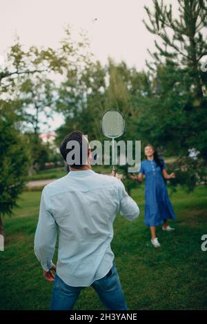 Junges erwachsenes Paar spielt Badminton im Park Stockfoto