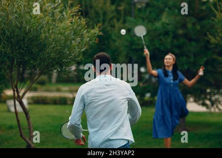 Mann und Frau spielen Badminton im Park Stockfoto