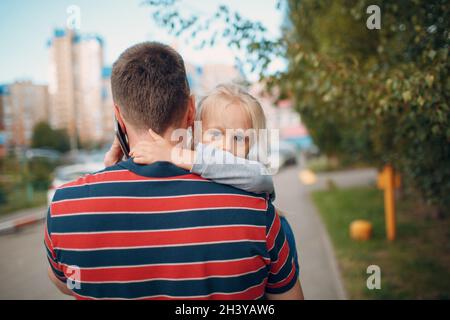 Rückansicht des Vaters, der mit seiner kleinen Tochter zur Kindergartenschule ging. Stockfoto