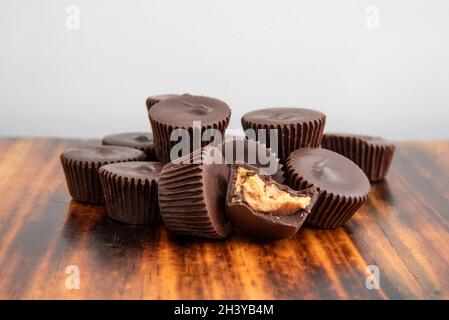 Ein Hügel aus Schokolade Erdnussbutterbecher auf einem dunklen Holztisch Stockfoto